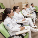 Cinco médicos do Hospital do Câncer de Barretos sentados vestindo jaleco branco
